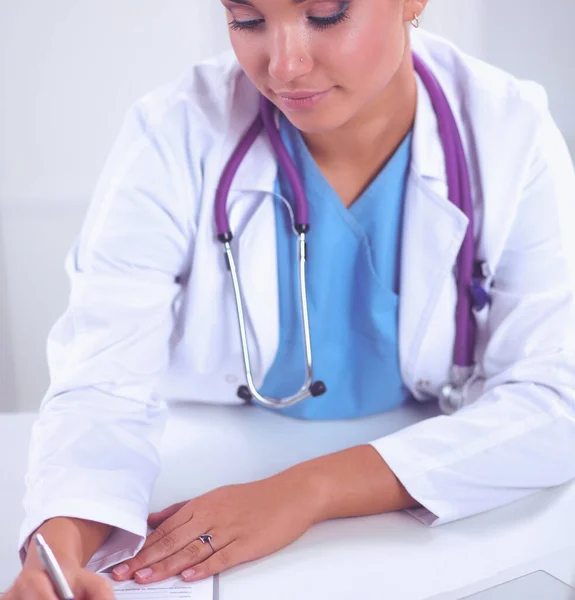 Doctora sentada en el escritorio y trabajando en un portátil en el hospital —  Fotos de Stock