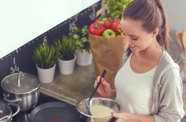 Genç bayan masanın yanında dururken mutfakta krep hazırlıyor. Mutfaktaki kadın. Mutfakta yemek yapmak..