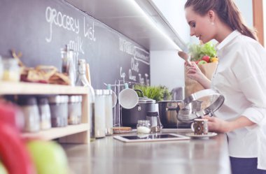 Genç kadın tableti mutfakta..