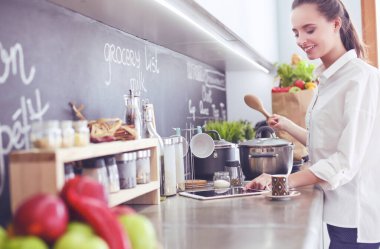 Genç kadın tableti mutfakta..