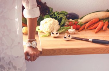 Mutfakta masanın yanında duran genç bir kadın.