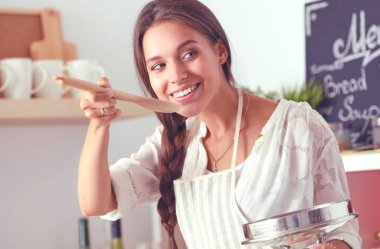 Mutfakta ahşap kaşıkla yemek pişiren kadın