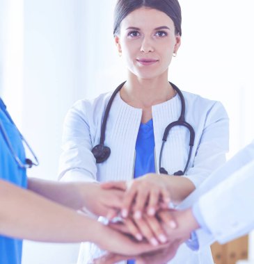 Bir grup doktor ellerini birleştiriyor. Yakın plan.
