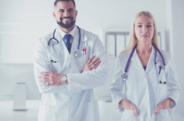 Bir doktor ekibi, kadın ve erkek, danışma odasında.