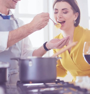 Evdeki mutfakta birlikte yemek pişiren çift..