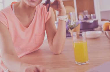 Mutfakta dizüstü bilgisayara benzeyen tariflerle gülümseyen genç bir kadın. Gıda blogcusu kavramı