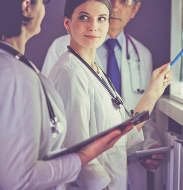 Bir grup doktor bir klinikte röntgenleri inceliyor, teşhis koymayı düşünüyorlar.