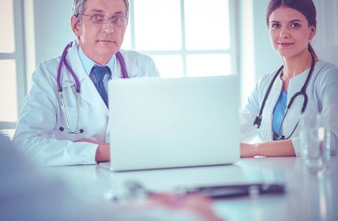 Parlak bir ofiste çalışan ciddi bir tıbbi ekip.