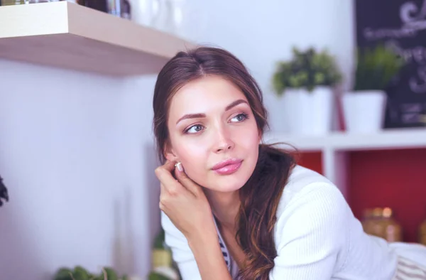 Jonge vrouw die bij een bureau in de keuken staat. Jonge vrouw . — Stockfoto