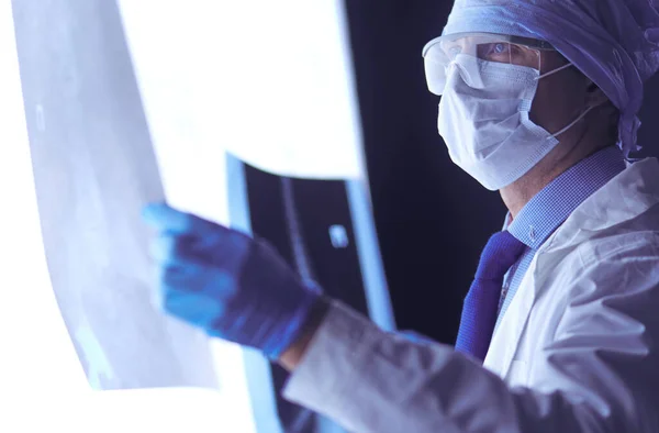 Jovem médico olhando imagem de raio-X em fundo branco isolado — Fotografia de Stock