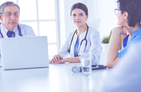 Équipe médicale sérieuse utilisant un ordinateur portable dans une salle de consultation lumineuse — Photo