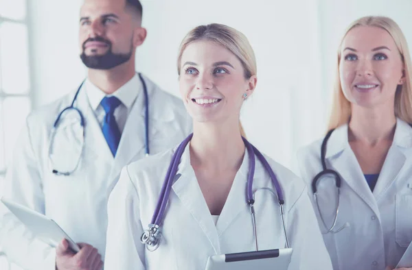 Glimlachende dokters staan allemaal samen terwijl ze werken. — Stockfoto
