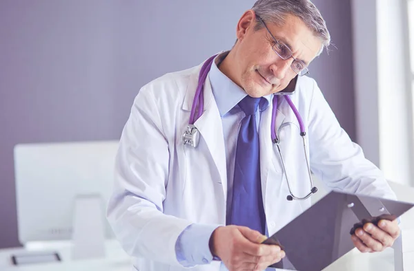 Ärztin schreibt Notizen auf Klemmbrett im Krankenhaus — Stockfoto