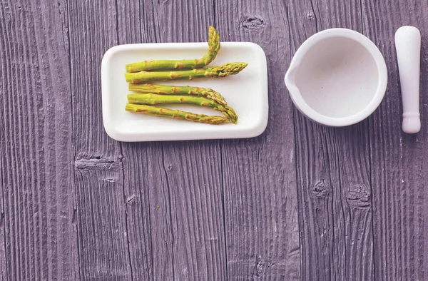 Grüner frisch geschälter Spargel in einer Porzellanschüssel — Stockfoto