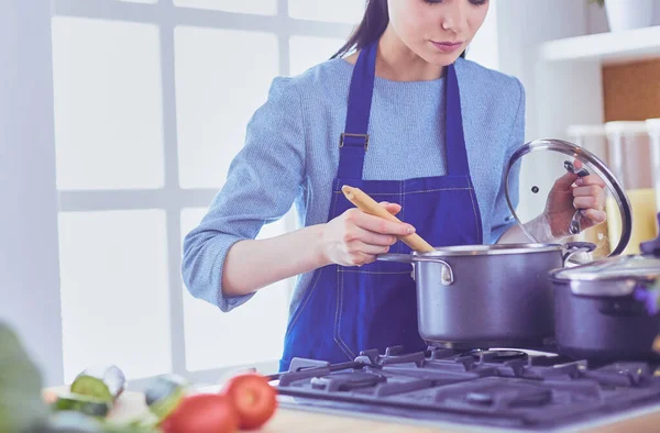 Mujer cocinera en cocina con cuchara de madera — Foto de Stock