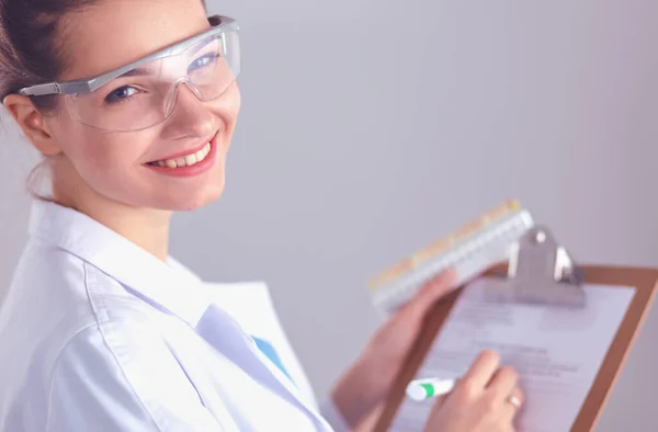 Attractive female dentist with tools , standing on gay background — Stock Photo, Image