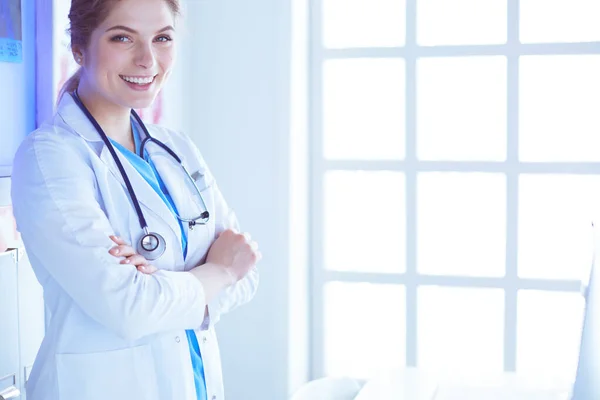 Jonge vrouw medic in wit uniform staan in klinieken kantoor — Stockfoto