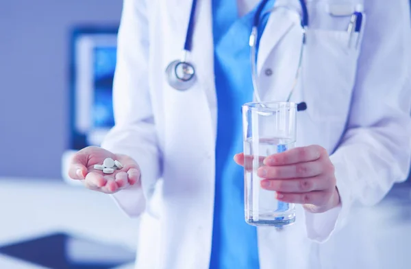 진료소에서 알약 과 물 한 컵을 들고 있는 의사들의 손을 찍은 사진. — 스톡 사진