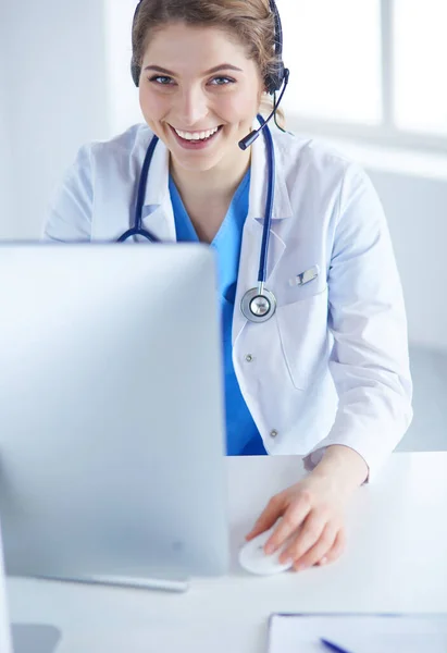 Dokter draagt een headset zittend achter een bureau met laptop — Stockfoto