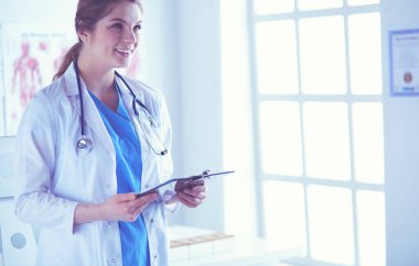 Üniformalı bir dosyayla gülümseyen kadın doktor