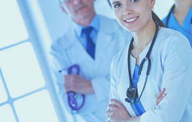 Bir grup doktor ve hemşire bir hastane odasında duruyor.