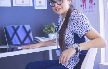 Parlak bir ofiste konuşan iki doktor.