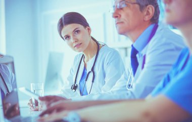 Doktorlar hastane konferans odasında birbirlerine danışıyorlar.