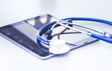 Tıbbi ekipman: Beyaz arka planda mavi steteskop ve tablet. Tıbbi ekipman