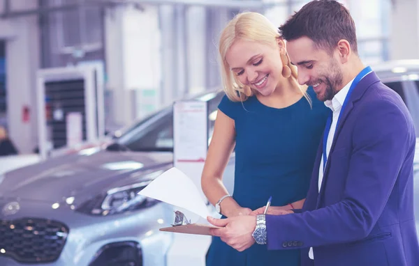 Πωλητής αυτοκινήτων πωλεί ένα αυτοκίνητο σε χαρούμενο πελάτη στην αντιπροσωπεία αυτοκινήτων και τα χέρια πάνω από τα κλειδιά — Φωτογραφία Αρχείου