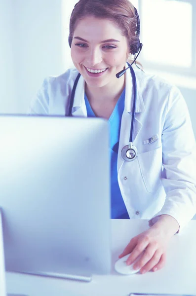 Dokter draagt een headset zittend achter een bureau met laptop — Stockfoto