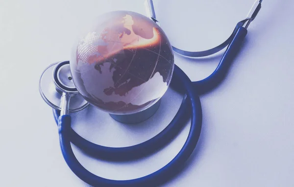 Global healthcare. Globe and stethoscope, studio shot.blue toned images — Stock Photo, Image