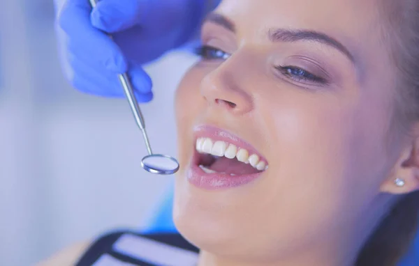 Mujer joven con la boca abierta examinando la inspección dental en el consultorio del dentista. — Foto de Stock