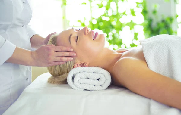 Hermosa mujer haciendo masaje facial en un salón de spa — Foto de Stock