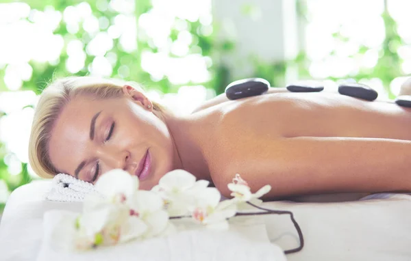 Mujer joven disfrutando de masajes en el salón de spa —  Fotos de Stock