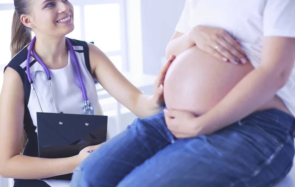 Giovane medico donna esaminando donna incinta presso la clinica. — Foto Stock