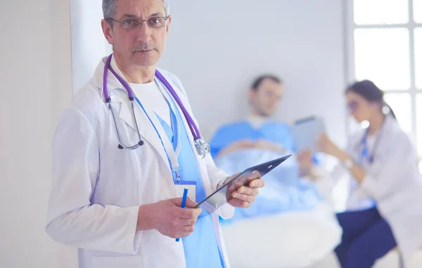 Läkaren håller mapp framför en patient och en läkare — Stockfoto