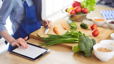 Mutfakta sebze doğrayan genç bir kadın.