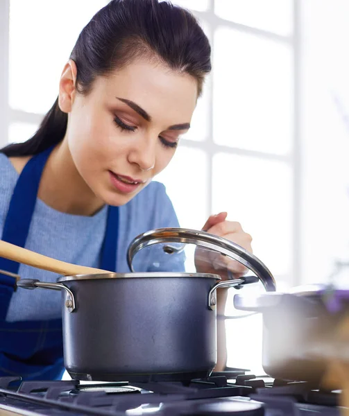 Cozinhar mulher na cozinha com colher de madeira — Fotografia de Stock