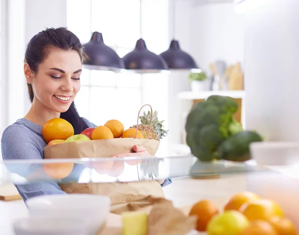 Le kvinna ta en färsk frukt ur kylskåpet, hälsosam mat koncept — Stockfoto