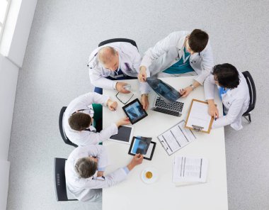 Tıbbi ekip masaya oturuyor ve tartışıyor.