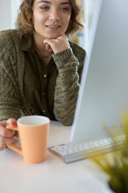 Öğrenci laptopla çalışıyor ve evdeki masada oturuyor.
