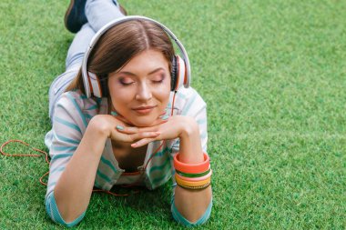 Yeşil çimlerde oturan genç bir kadın. Portreit genç bayan