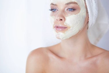 Genç bir kadının banyoya yüz pudrası sürerken fotoğrafı.