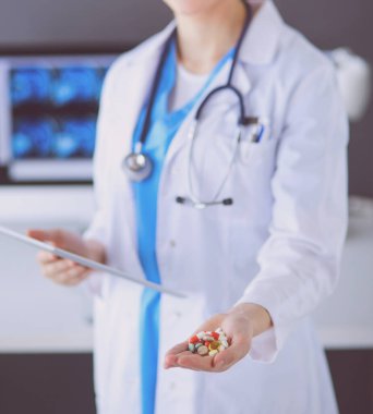 Doktorların ellerinde haplar ve tablet tutarken yakın plan çekimleri..