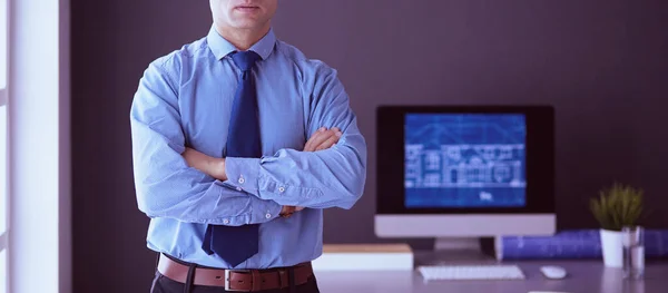 Empresário sorridente com touchpad em pé no local de trabalho no escritório — Fotografia de Stock