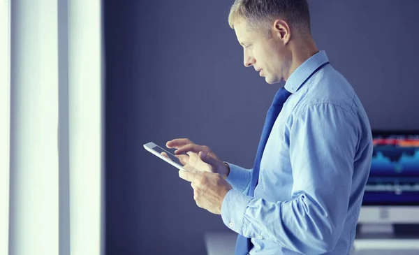 Glimlachende zakenman met touchpad op kantoor — Stockfoto