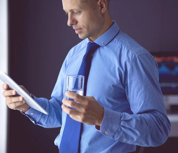 Młody poważny biznesmen w słuchawkach patrząc na ekran tabletu — Zdjęcie stockowe