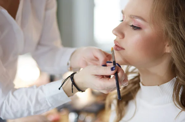 Hermosa joven modelo mujer consiguiendo maquillaje de moda — Foto de Stock