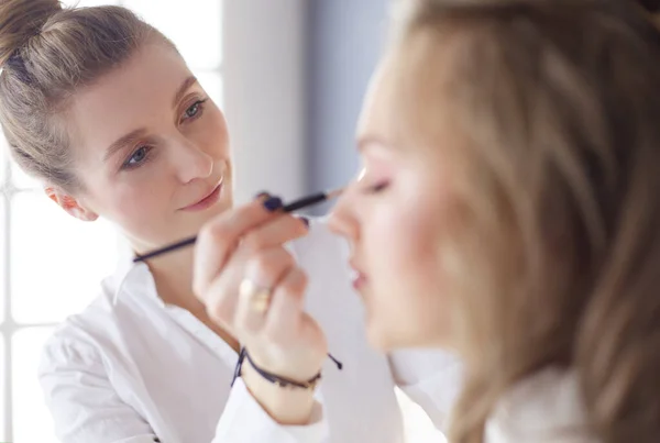 Beautiful young model woman getting fashion make-up — Stock Photo, Image