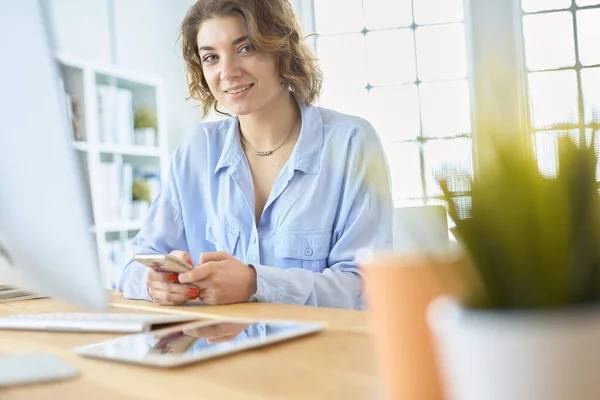 Mulher feliz trabalhando usando vários dispositivos em uma mesa em casa — Fotografia de Stock